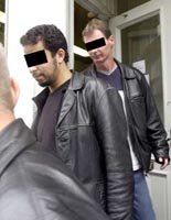 Unidentified suspects being led out of the bookstore in April 2002.